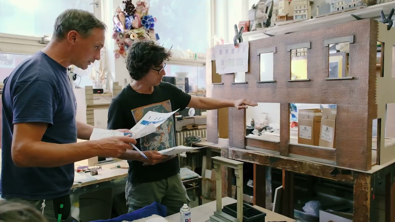 Maquetistas trabajando en la ciudad en miniatura del comercial de Oura
