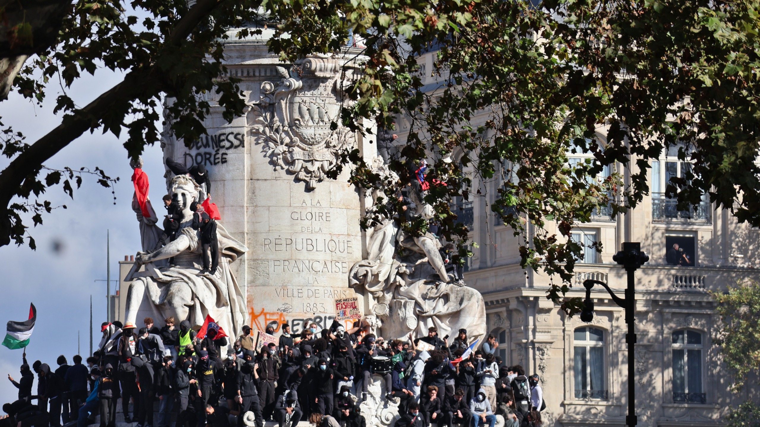Manifestantes sobre el monumento de la plaza de la República en París durante la protesta del 17 de octubre de 2026