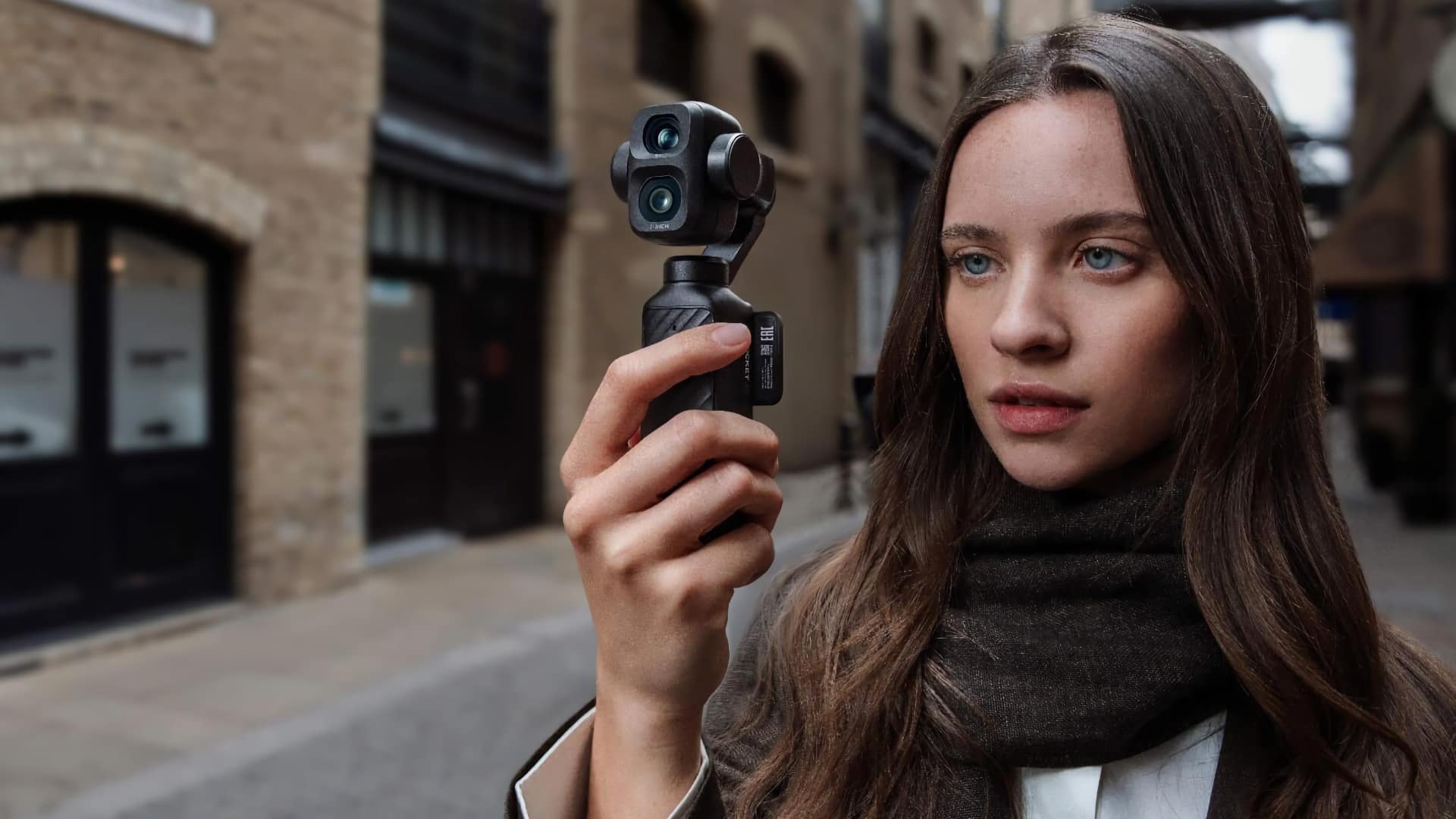 Mujer sosteniendo la DJI Osmo Pocket 4P en una calle