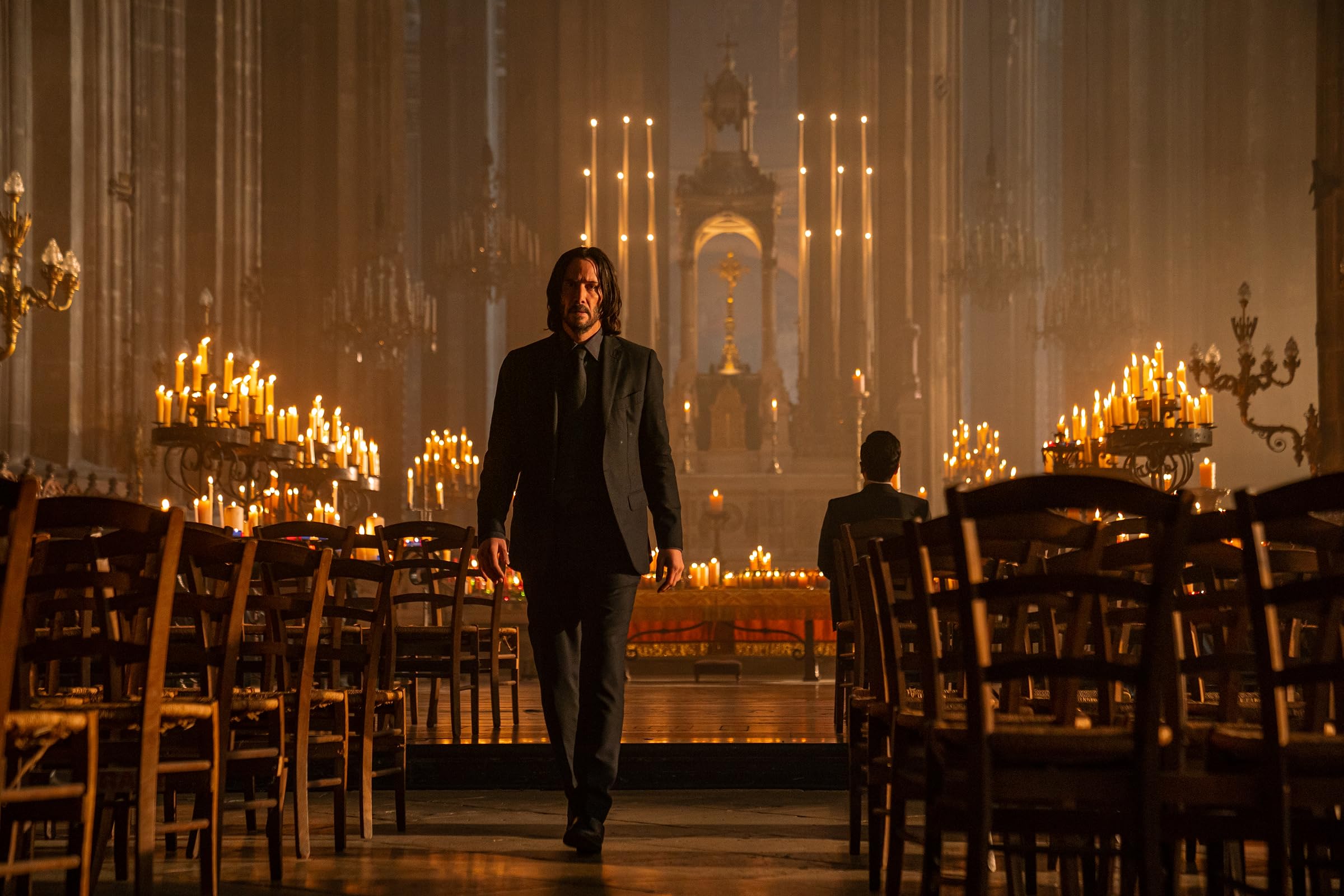 Keanu Reeves en un salón iluminado con velas en John Wick: Chapter 4
