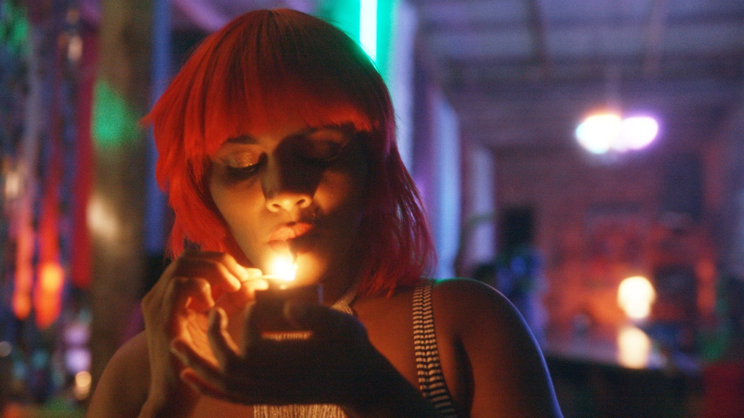Gessica Généus con peluca roja enciende un cigarrillo en una escena nocturna de Marie Madeleine