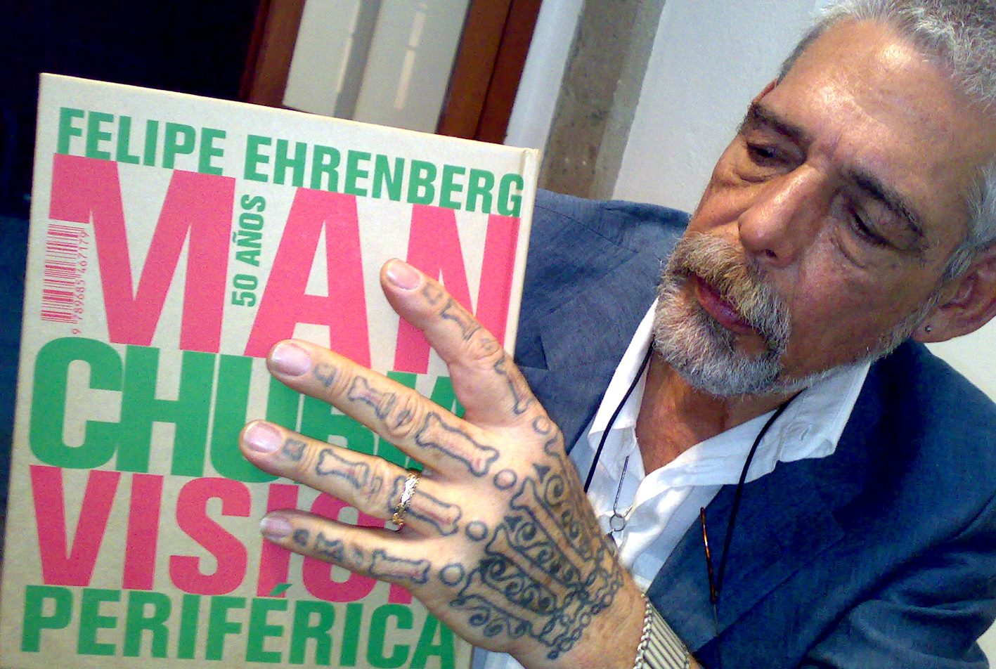 Felipe Ehrenberg con un libro de su obra
